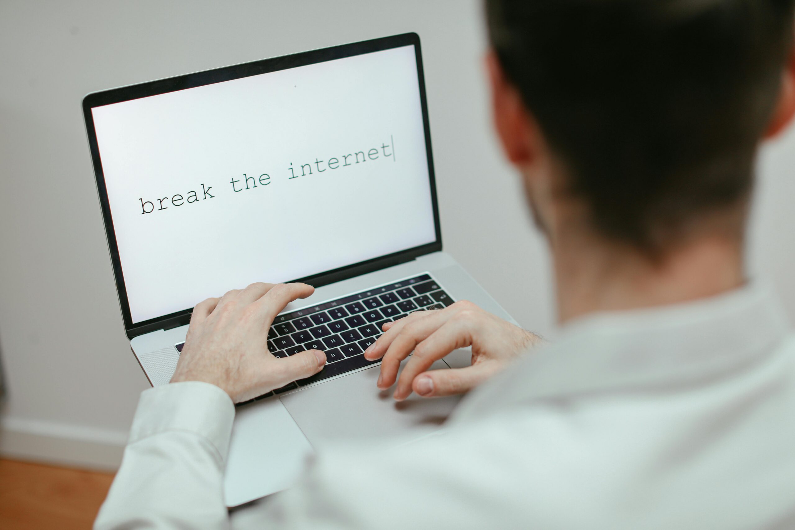 A person typing on a laptop showing the provocative message 'break the internet'.